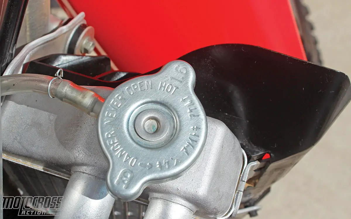 Our 2017 Honda CRF450 ran hot. The simplest solution to replace the stock 1.1 kg/mm radiator cap with a higher pressure 1.6 kg/mm cap. The higher the pressure, the higher the boiling point of water.