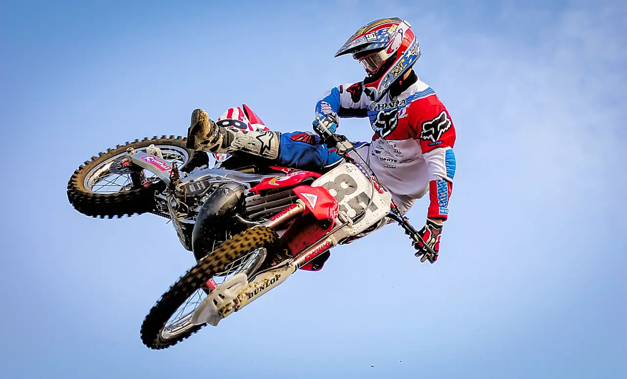 Hombre montando un motocross en un traje protector