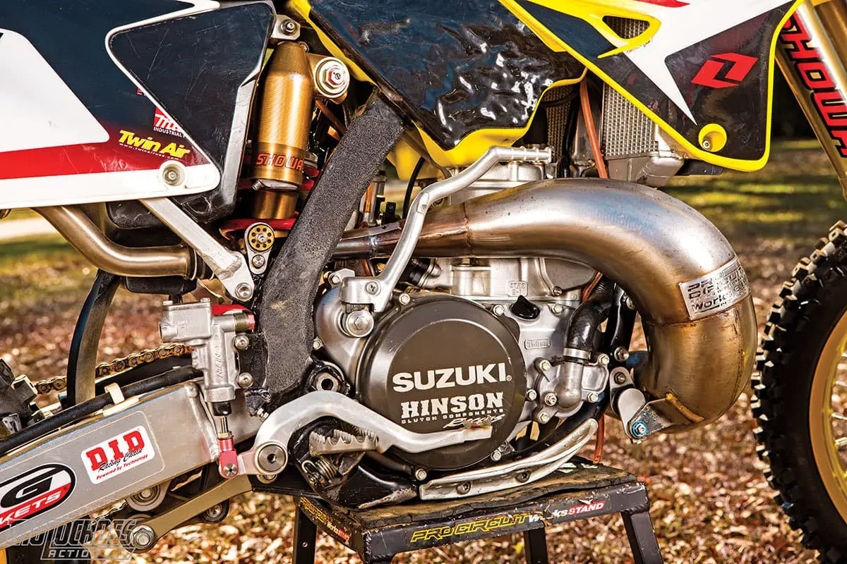 Werkseitig verwendete Suzuki Pro Circuit-Auspuffanlagen mit einer Hinson-Kupplung (mit einem speziell geätzten Suzuki-Kupplungsdeckel) und One Industries-Grafiken. Beachten Sie die untere Rohrhalterung, die Zugstangen und die ausgebohrten Aluminiumscheiben.